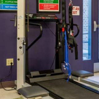 A treadmill and other gym equipment set up in an indoor fitness area.