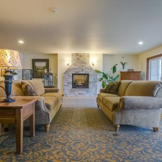 A cozy living room featuring a stone fireplace, two plush sofas, and warm lighting.
