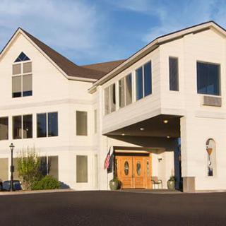 A large, modern residential building with a peaked roof and numerous windows.