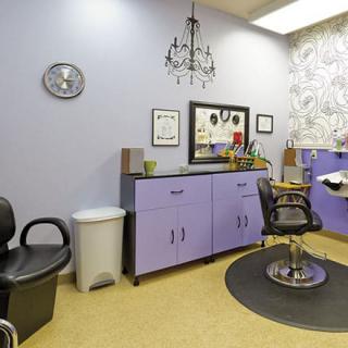 A well-decorated salon interior with a hairdressing chair and mirror.