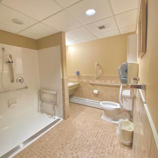 A well-designed accessible bathroom featuring a shower, toilet, and sink.