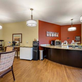 A cozy lobby area featuring a coffee and refreshment station with modern lighting and comfortable seating.