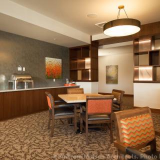 A modern dining area featuring elegant furniture and warm lighting.