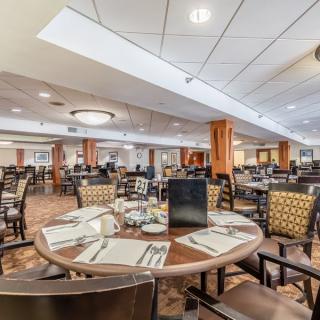 A spacious and elegantly designed restaurant dining area with neatly arranged tables and chairs.