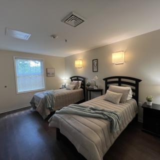 A modern bedroom with two neatly made beds and soft lighting.