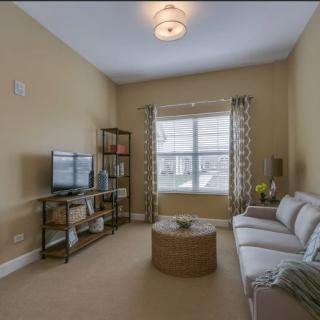 Cozy living room with a sofa, TV, and natural light.