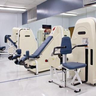 A gym equipped with various exercise machines for strength training.
