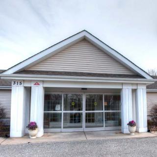Front view of a building entrance with columns and glass doors.