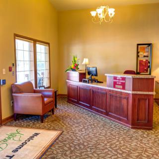 A welcoming reception area with a wooden desk, comfortable seating, and elegant lighting.