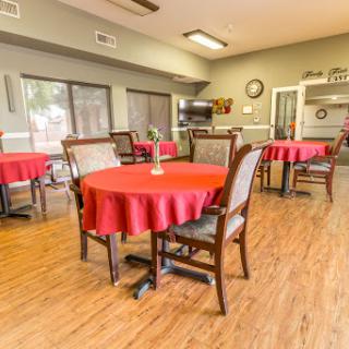 A cozy dining area featuring red tablecloths and wooden chairs, perfect for casual gatherings.