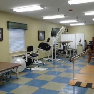 A physical therapy room equipped with various rehabilitation exercise machines and tools.