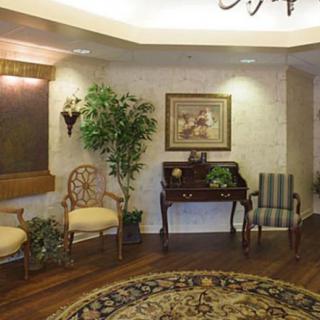 A cozy lobby with elegant furniture, decorative plants, and artwork on the walls.