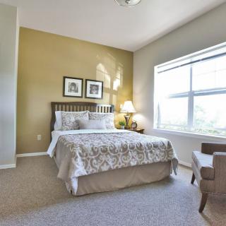 A cozy bedroom with a large window and elegant decor.