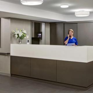 A modern office reception area with a receptionist at the desk.