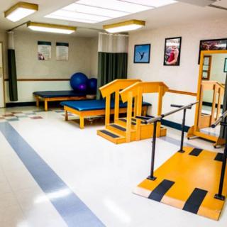 A physical therapy room equipped with various rehabilitation and exercise equipment.