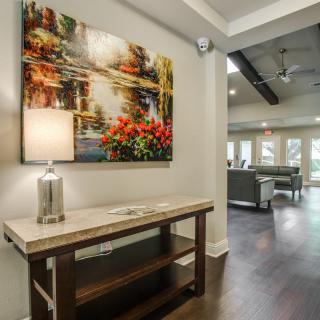 A cozy living space featuring a decorative table with a lamp and artwork on the wall.