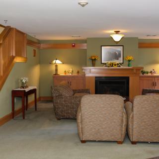 A cozy living room featuring a fireplace, comfortable seating, and warm wooden accents.