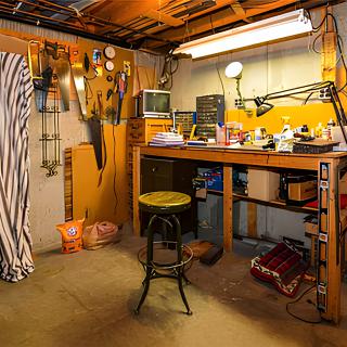 A well-organized basement workshop with a workbench and tools.