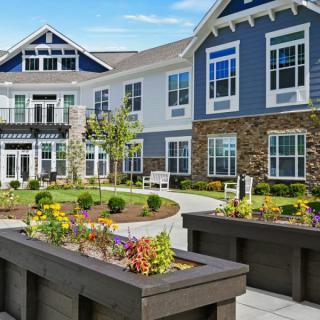 Modern residential building with landscaped garden and flower beds.