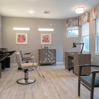 A modern hair salon interior with stylish chairs and large mirrors.
