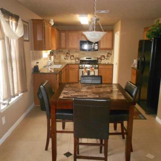 A cozy kitchen and dining area with wooden cabinets, a dining table, and modern appliances.