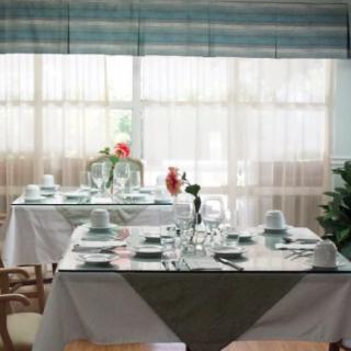 An elegantly set dining table in a restaurant with natural lighting.