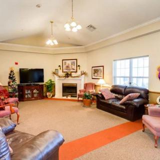 A cozy living room featuring comfortable sofas, a television, and a fireplace with decorative elements.