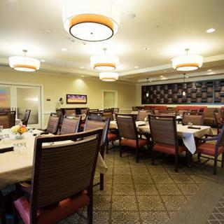 A well-lit dining area with neatly arranged tables and chairs.