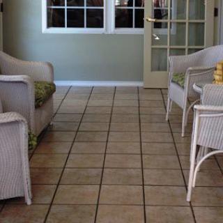 A cozy room with wicker furniture and tiled flooring.