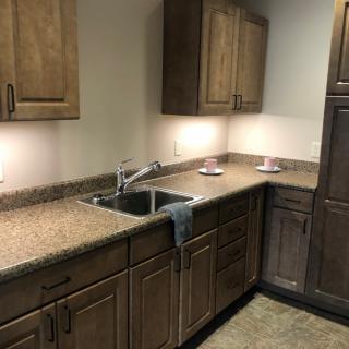 A modern kitchen interior with wooden cabinets and a granite countertop.