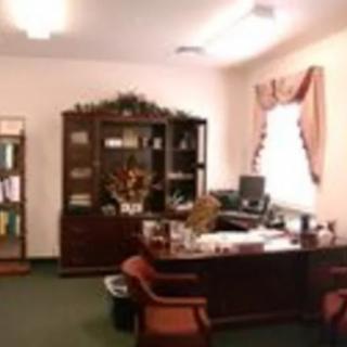A well-organized office with a desk, computer, and bookshelf.
