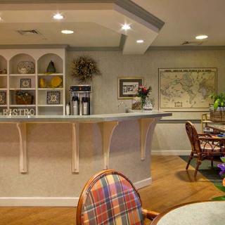 A cozy cafe interior featuring a counter, seating area, and warm lighting.