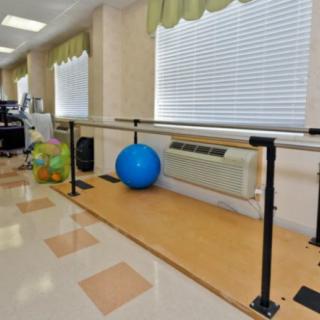 A rehabilitation room featuring parallel bars and exercise balls for physical therapy exercises.