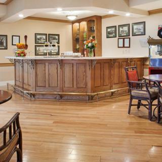 A cozy bar with a wooden counter and seating area.