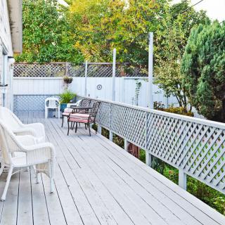 A spacious outdoor deck with chairs and a scenic view of surrounding trees.