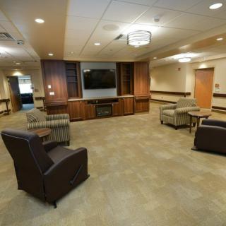 A modern lounge with comfortable seating and a large television.
