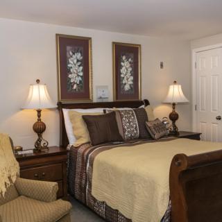 A cozy bedroom with a neatly made bed and elegant decor.
