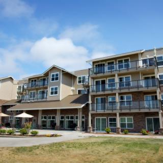 A modern residential building with balconies under a blue sky.