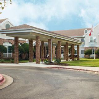 A building entrance with a covered canopy and landscaped surroundings.