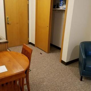 A small office space with a wooden table, chairs, and a blue armchair.