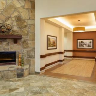 A cozy interior space featuring a stone fireplace, artwork, and a well-lit hallway.