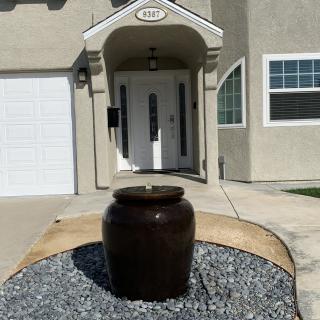 A modern house entrance with a small fountain in front.