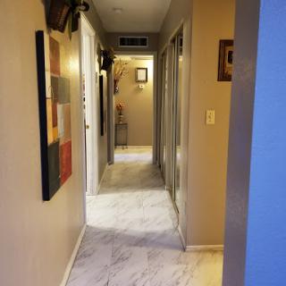A view of a well-decorated hallway featuring artwork on the walls and elegant flooring.
