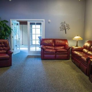 A cozy living room with leather sofas and soft lighting.