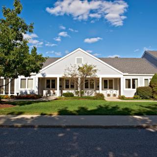A charming residential home with a well-maintained front yard, set against a clear blue sky.