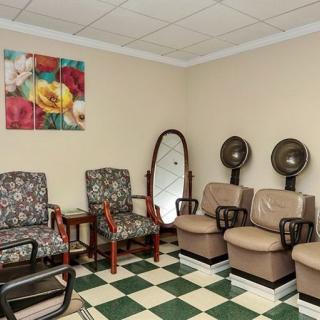 A cozy salon waiting area with chairs and hair dryers.