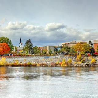 A serene autumn landscape showcasing vibrant foliage and a calm water reflection.