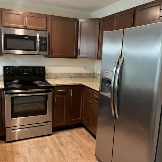 Modern kitchen with stainless steel appliances and wooden cabinets.