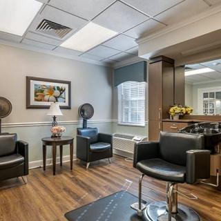 A modern salon interior with comfortable chairs, mirrors, and hair drying stations.