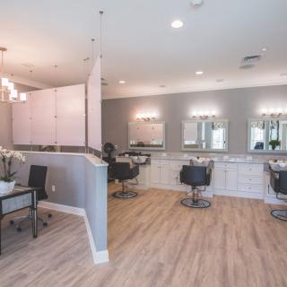 A modern salon interior with stylish chairs, mirrors, and bright lighting.